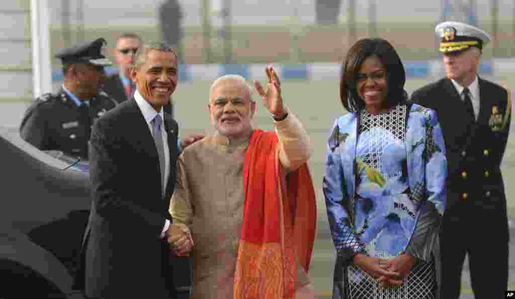 Presiden Barack Obama, kiri, berjabat tangan dengan Perdana Menteri Narendra Modi, tengah, didampingi Ibu Negara Michelle Obama, saat tiba di Pangkalan Angkatan Udara Palam di New Delhi (25/1).