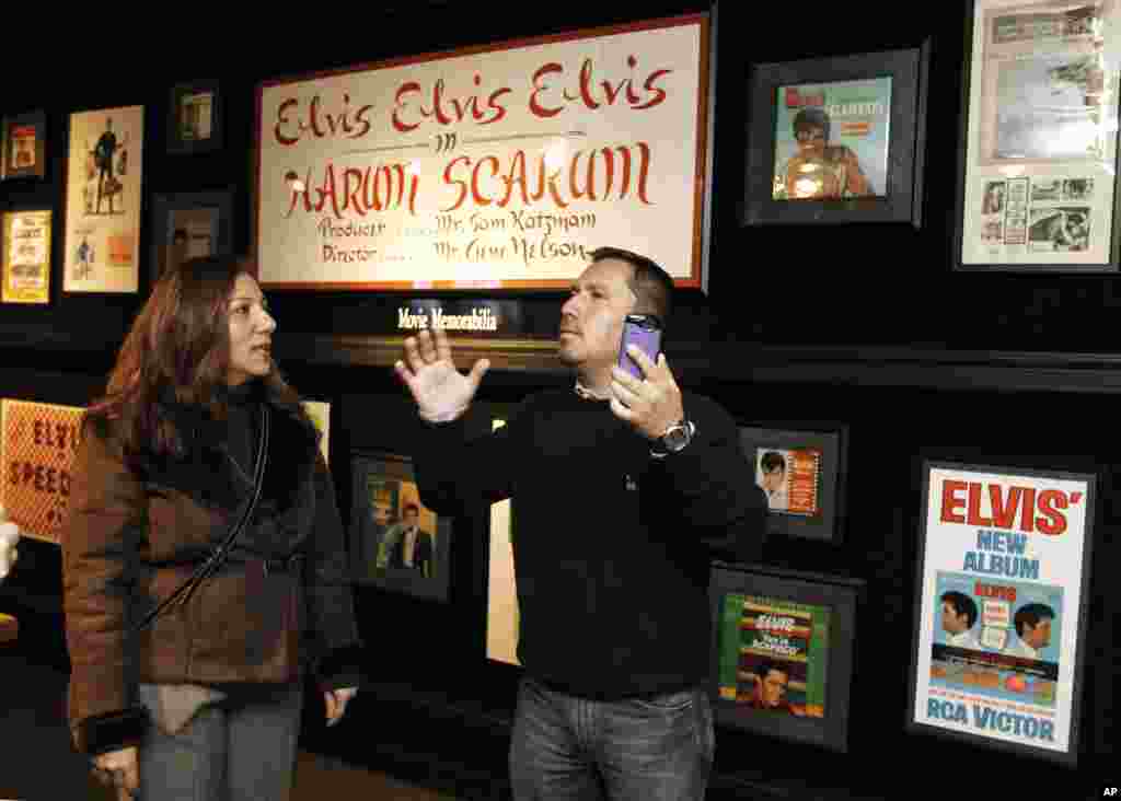 Edison Pena, right, and his translator, Lina Makarem, view some of Elvis Presley's movie memorabilia at Graceland, Elvis Presley's home, on Friday, Jan. 7, 2011, in Memphis, Tenn.