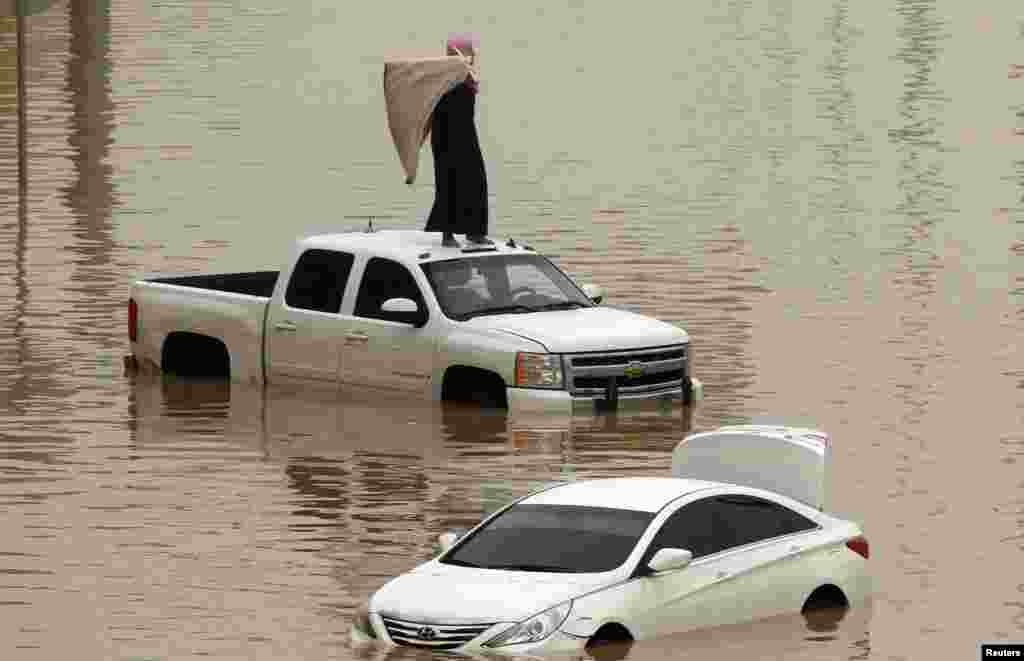 Mobil-mobil terendam banjir yang melanda kota Riyadh, Saudi Arabia.