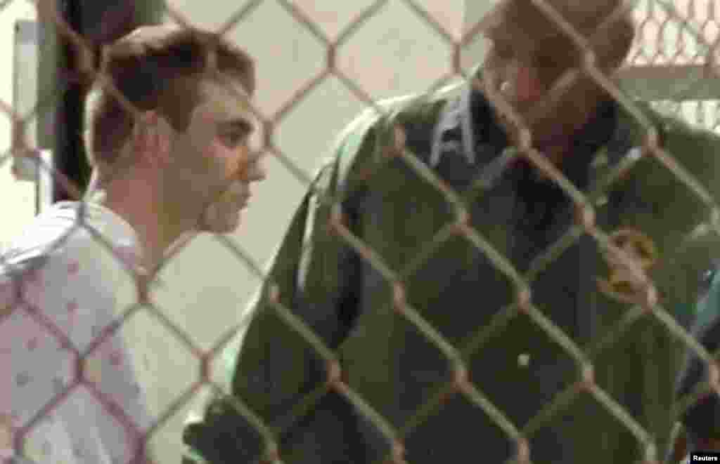 Police escort Nikolas Cruz into Broward County Jail following a shooting incident at Marjory Stoneman Douglas High School, in Fort Lauderdale, Florida, Feb. 15, 2018 in a still image from video.
