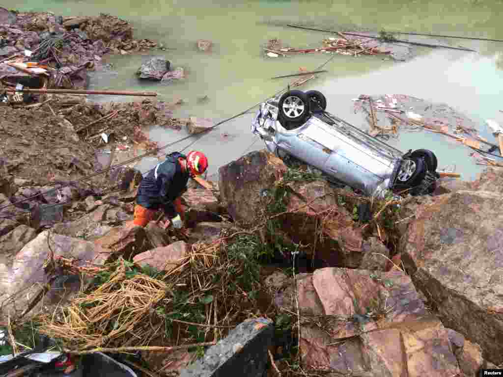 Petugas penyelamat mencari korban topan Megi, di desa Sucun, Lishui, Zhejiang, China.