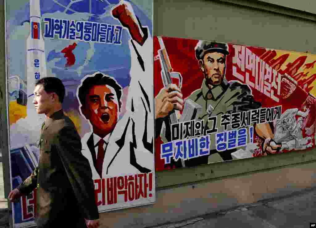 A man walks past propaganda posters that threaten punishment to the "U.S. imperialists and their allies," Pyongyang, North Korea, March 26, 2013.