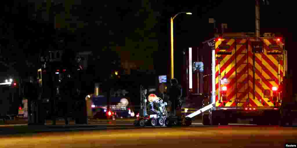 Police officers and their vehicles line the street in Redlands, California outside the house of one of the suspects in San Bernardino shooting rampage Dec. 2, 2015.
