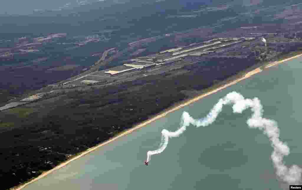 Pilot akrobatik Sean Tucker di dalam pesawat Oracle melakukan terjun spiral sebelum acara Pertunjukan Atraksi Air dan Udara Chicago ke-55 dekat Gary, Indiana, AS, 15 Agustus 2013. Pertunjukan Atraksi Udara dan Air Chicago akan diadakan pada akhir pekan.