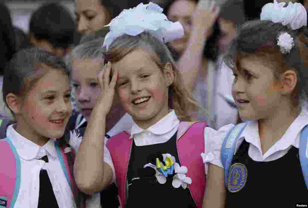 Schoolgirls talk during morning assembly in a school in the southern coastal town of Mariupol, Ukraine, Sept. 1, 2014.