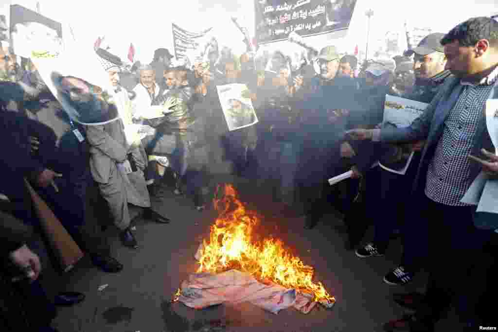 Supporters of Shi'ite cleric Moqtada al-Sadr burn fabric painted to resemble the national flags of Israel, the United Kingdom and the U.S. during a demonstration condemning the execution of Shi'ite cleric Nimr al-Nimr in Saudi Arabia, in Baghdad, Jan. 4,