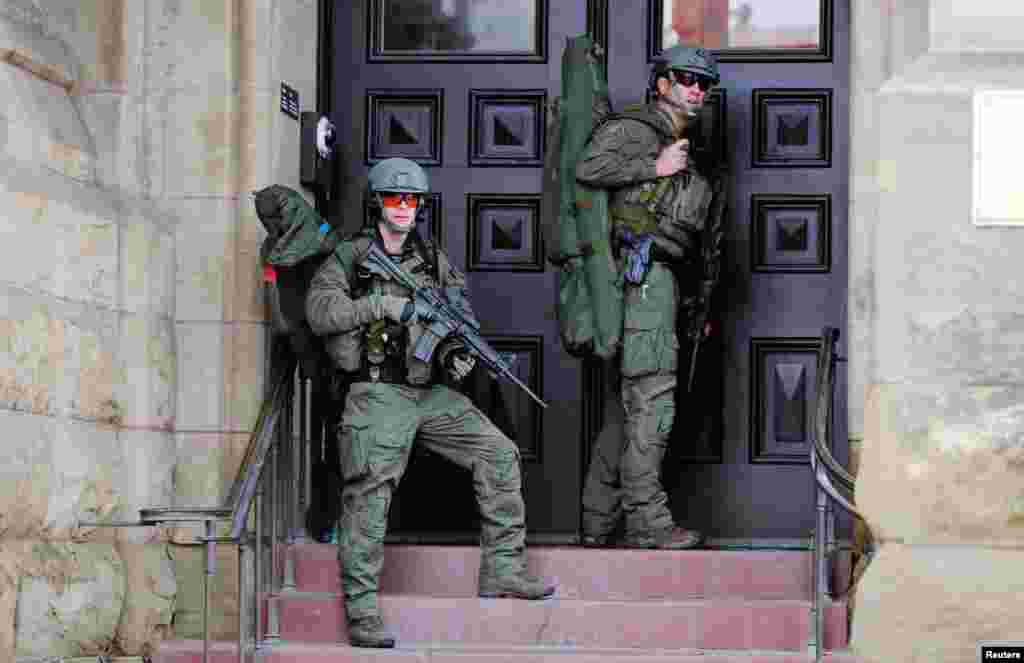 Armed RCMP officers guard the front of Langevin Block on Parliament Hill following a shooting incident in Ottawa.