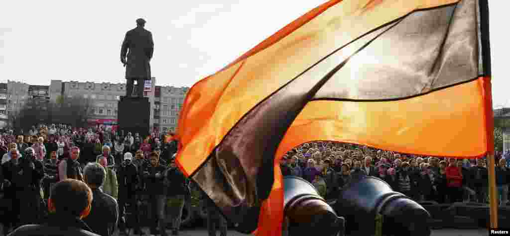 Bendera dalam warna-warna Pita Santo George, yang menjadi simbol sentimen Pro-Rusia, berkibar, sementara para pendukung Pro-Rusia berkumpul di luar kantor Walikota di Slaviansk, Ukraina. 