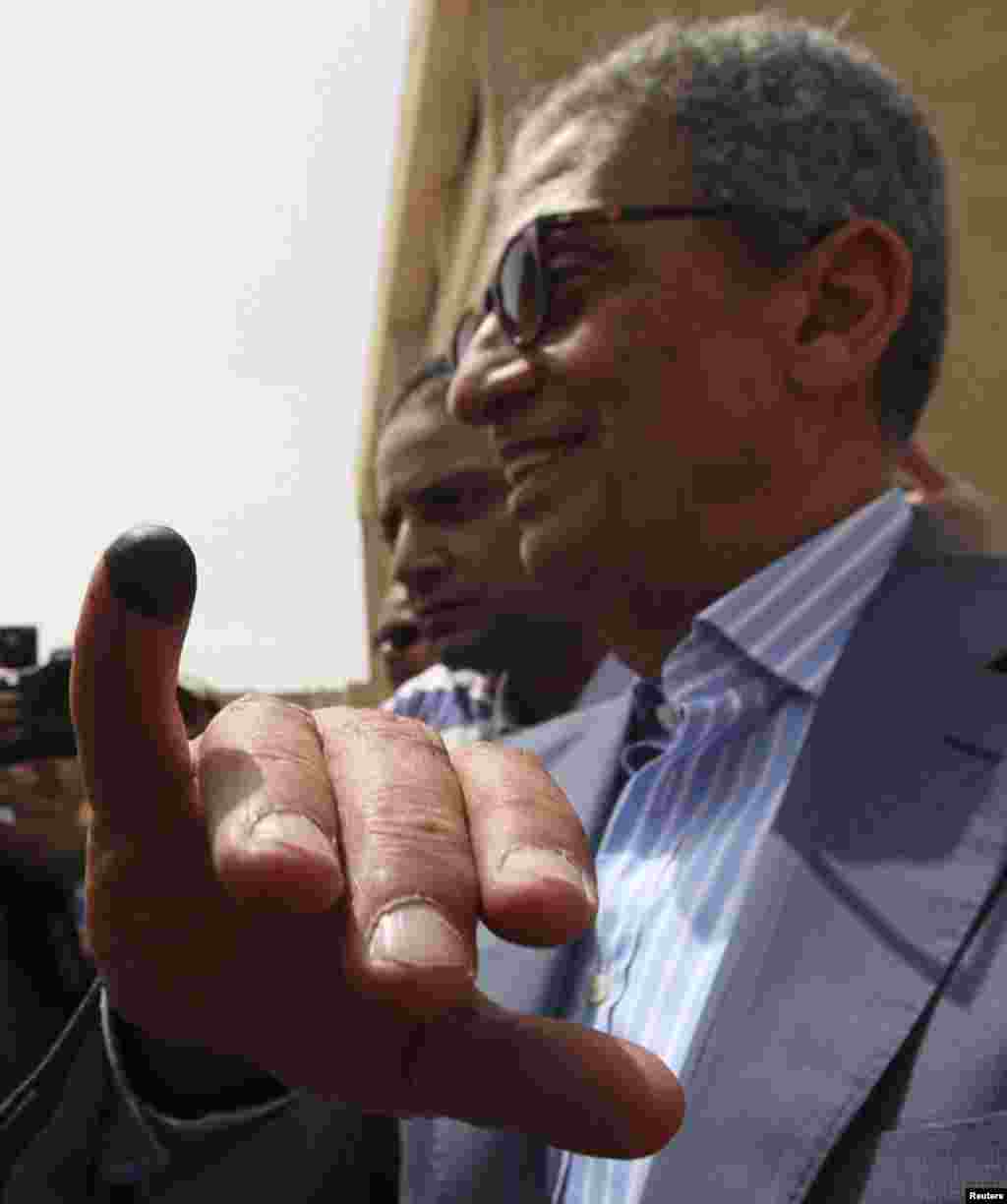 Egyptian presidential candidate Amr Moussa shows his ink-stained finger after casting his vote at a polling station in Cairo May 23, 2012.