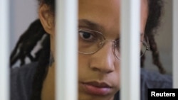 Pebasket AS Brittney Griner duduk di balik sel terdakwa dalam persidangan pembacaan putusan atas kasus narkoba yang menjeratnya. Persidangan digelar di Khimki, Moskow, Rusia, pada 4 Agustus 2022. (Foto: Reuters/Evgenia Novozhenina)