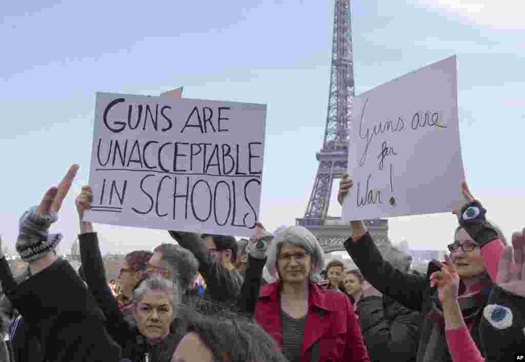 People hold banners during the "March For Our Lives" event in Paris, March 24, 2018.