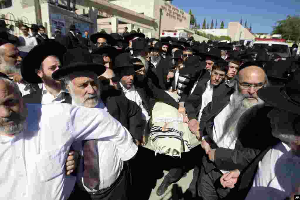 Ultra-Orthodox Jewish men carry the body of 17-year-old student Shalom Baadani during his funeral in Jerusalem, Nov. 7, 2014.