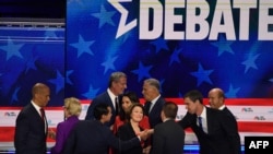 Wagombea urais wa chama cha Demokrat, kutoka kushoto, Cory Booker, Elizabeth Warren, Julian Castro, Bill de Blasio, Tulsi Gabbard, Amy Klobuchar, Jay Inslee, na muogozaji mdahalo Chuck Todd, Beto O’Rourke na John Delaney wakisalimiana baada ya kumaliza mdahalo. 