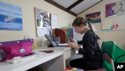 FILE - Rachel Keenan takes a live class online at her home in San Francisco.
