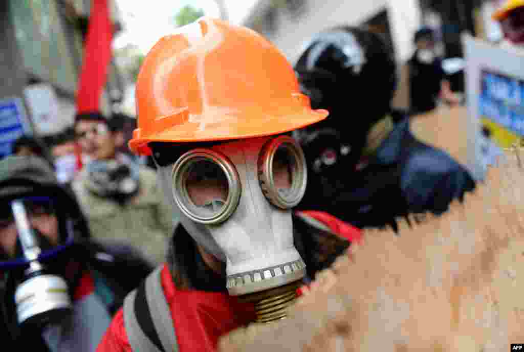 Seorang pengunjuk rasa Turki mengenakan masker gas dan helm untuk melindungi dirinya selama bentrokan pengunjuk rasa dengan polisi anti huru-hara, yang berupaya menghalangi mereka saat menuju Lapangan Taksim di Istanbul, dalam peringatan Hari Buruh Internasional.