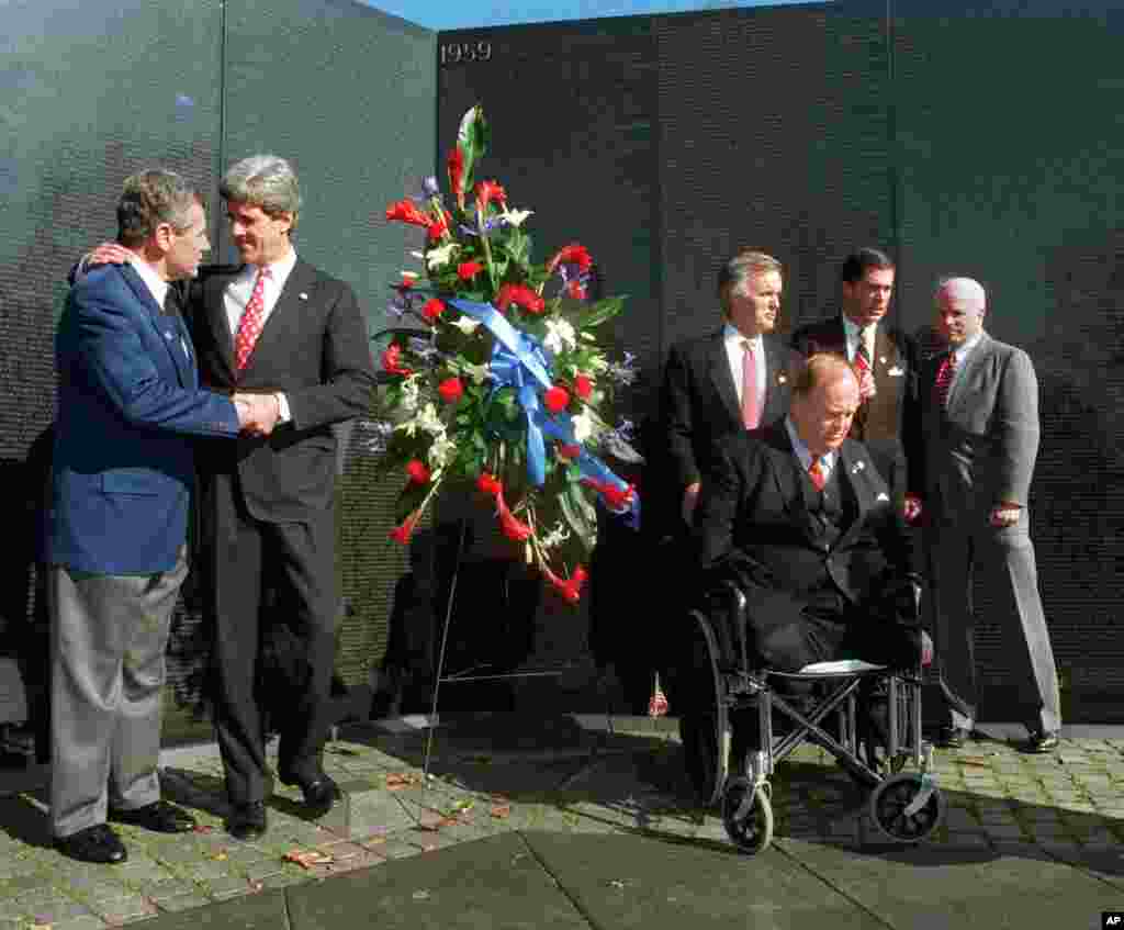 Then Senator Chuck Hagel, left, and Senator John Kerry, shake hands while with other senators who served in Vietnam at the 15th anniversary of the Vietnam Veterans Memorial, March 7, 1997.
