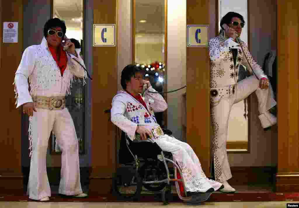 Para kontestan amatir (dari kiri) Phil Bailey, John Hindle, dan Emir Eren berpose di bilik-bilik telepon dalam acara tahunan Kontes dan Konvensi Tribut untuk Artis Elvis se-Eropa di Birmingham, Inggris. 