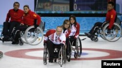 Canada's Dennis Thiessen delivers a stone during their wheelchair curling game against China at the 2014 Sochi Paralympic Winter Games, Mar. 11, 2014. 