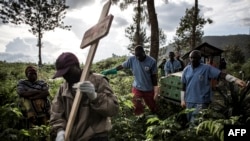 FILE - Health workers carry a coffin containing a victim of Ebola virus on May 16, 2019 in Butembo.