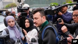 Članovi grupe Columbia University Apartheid Divest, uključujući Mahmouda Khalila, centar, okruženi predstavnicima medija ispred kampusa Univerziteta Columbia, 30. aprila 2024., u New Yorku.