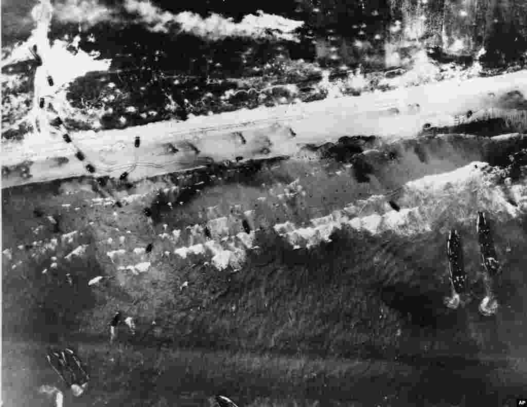 Assault vehicles storm the beach as Allied landing craft invade the shore of Normandy, France, June 6, 1944. 