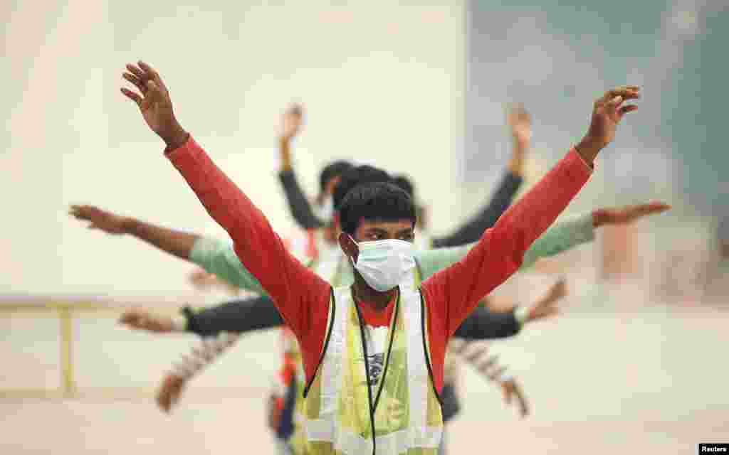 Sejumlah pekerja konstruksi memakai masker wajah untuk melindungi mereka dari kabut asap tebal saat mereka melakukan senam pagi di Singapura.