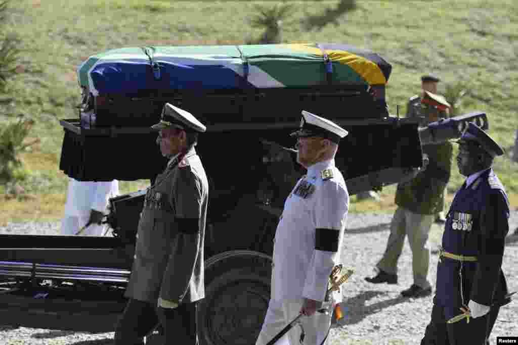 Peti mati mantan presiden Afrika Selatan Nelson Mandela dibawa di atas kereta senjata untuk penguburan tradisional setelah upacara pemakaman di Qunu, Afrika Selatan, 15 Desember 2013.