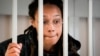 Brittney Griner, pebasket WNBA dan dua kali peraih medali emas Olimpiade, berbicara dengan pengacaranya yang berdiri di balik jeruji di ruang pengadilan sebelum sidang, di Khimki di luar Moskow, Rusia, Selasa, 26 Juli 2022. (Foto: AP)