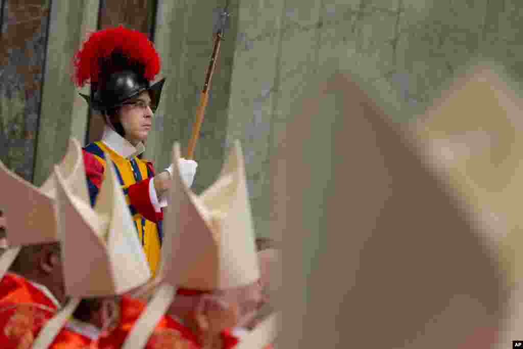 A Vatican Swiss guard is seen as cardinals attend a Mass for the election of a new pope inside St. Peter's Basilica, at the Vatican, March 12, 2013.