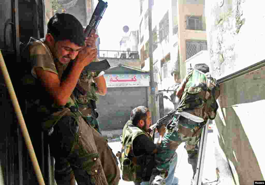 Thành viên của Quân đội Syria Tự do đụng độ với binh sĩ quân đội chính phủ trong quận Saif al-Dawla của Aleppo, 22/8/12