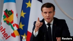 FILE - French President Emmanuel Macron gestures as he delivers a speech after a meeting via video-conference with leaders of West African G-5 Sahel nations, in Paris, France, Feb. 16, 2021. 