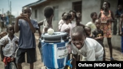 Niños se lavan las manos en prevención de adquirir el virus del eebola en Clara, un pueblo al norte de Monrovia.