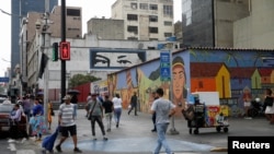 ARCHIVO - Venezolanos caminan por una calle de Caracas. 