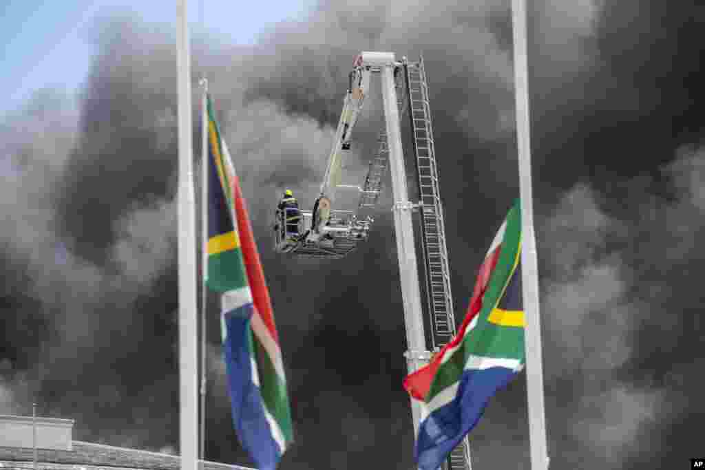 Firemen spray water on flames erupting from a building at South Africa's Parliament in Cape Town.