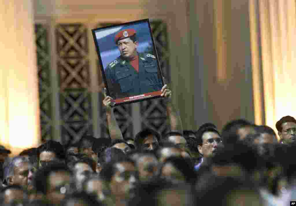 A man holds up an image of Venezuela's President Hugo Chavez during a demonstration in Managua, Nicaragua, March 5, 2013.