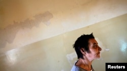 FILE - A patient is seen walking a hallway at a mental health institution in the Balkans.