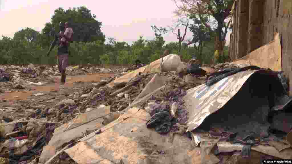 A father and son walk near debris at the New Kochgoro camp in Abuja, March 7, 2016. (N. Pinault / VOA)