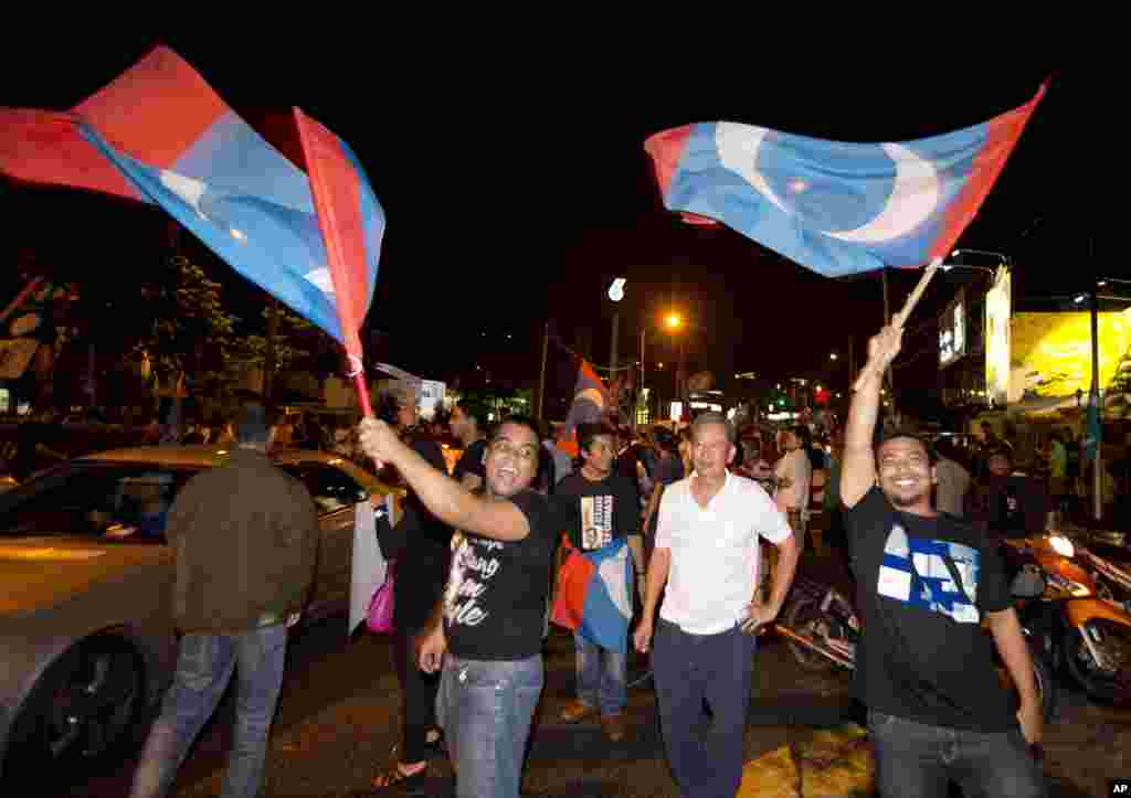 Para pendukung pemimpin oposisi Anwar Ibrahim melambaikan bendera-bendera setelah tempat-tempat pemungutan suara ditutup di Kuala Lumpur (5/5).