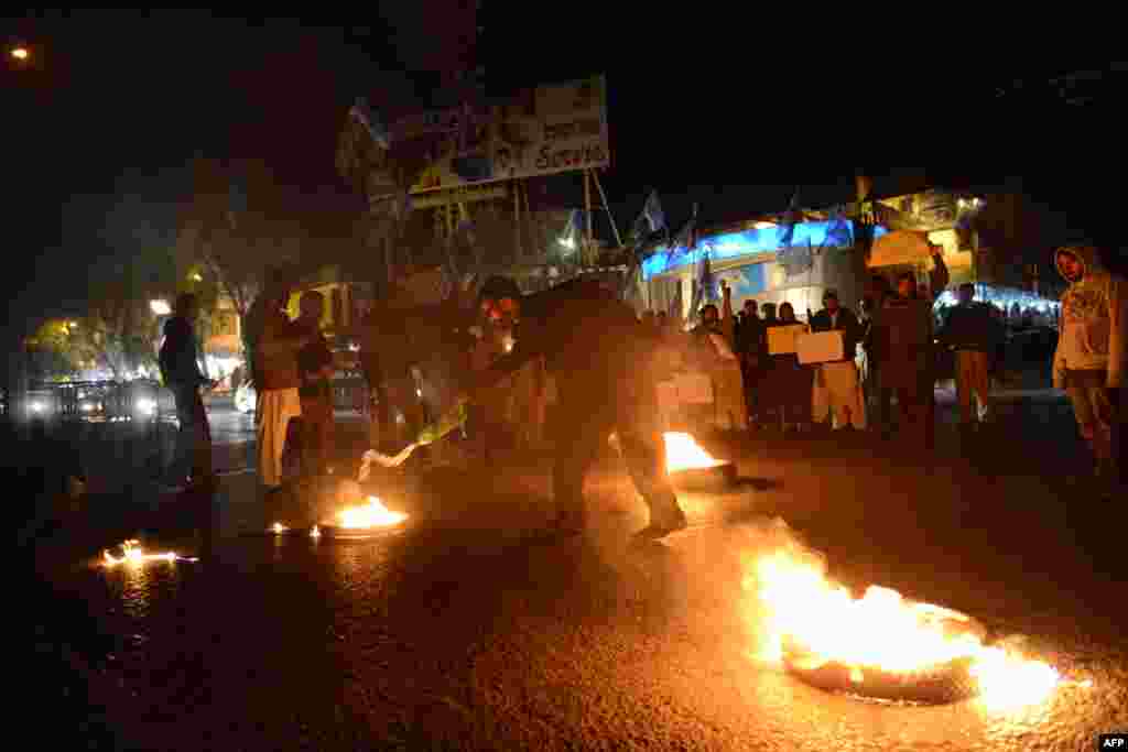 An activist of Jamaat-e-Islami Pakistan sets a tire on fire in a protest against the execution of a senior Bangladeshi opposition leader known as the 'Butcher of Mirpur', making him the first person to be put to death for massacres committed during the country's bloody 1971 war of independence, in Islamabad.