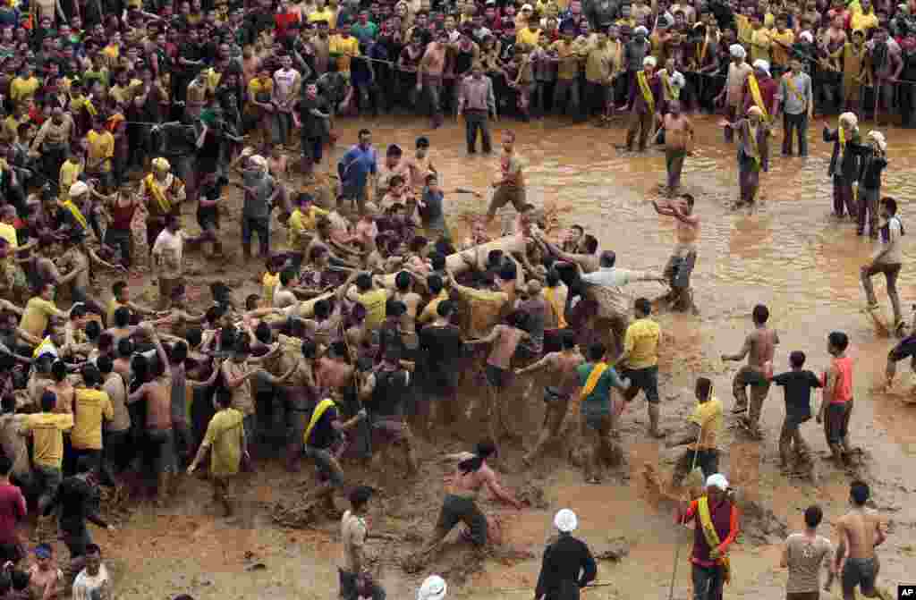 Para pria dari suku Jaintia mengangkat 'pohon suci' dalam festival tradisional di kota Jowai, India timur laut.