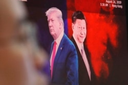 FILE - A computer screen shows images of Chinese President Xi Jinping, right, and U.S. President Donald Trump as a currency trader works at the KEB Hana Bank headquarters in Seoul, South Korea, Aug. 26, 2019.