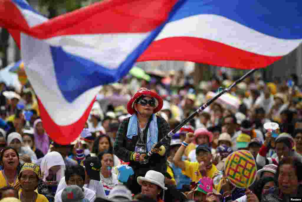An anti-government protester waves a flag during a rally outside a compound of the country's parliament where members of the Senate are gathered for a meeting, in Bangkok, Thailand.