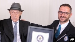 FILE - In this photo supplied by Guinness World Records, Marco Frigatti, head of records for Guinness World Records, presents Israel Kristal a certificate for being the oldest living man, in Haifa, Israel, March 11, 2016. 
