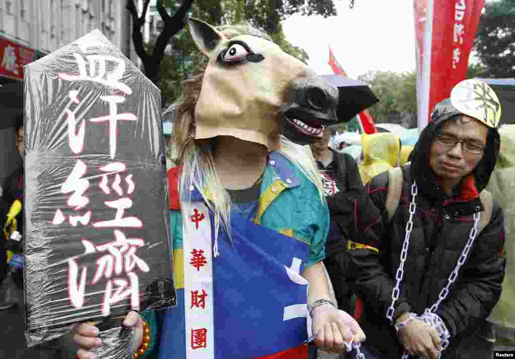 Demonstran memakai topeng kepala kuda dan rantai dalam peringatan Hari Buruh di depan gedung pemerintahan di Taipei, Taiwan (1/5).