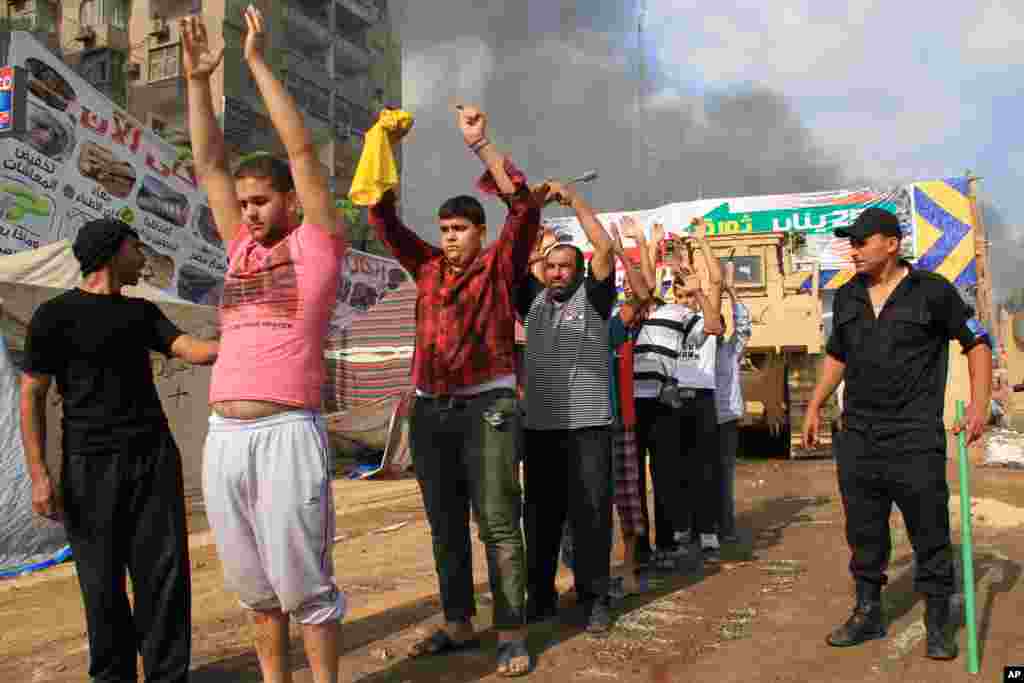 Egyptian security forces detain protesters as they clear a sit-in by supporters of ousted Islamist President Mohammed Morsi in the eastern Nasr City district of Cairo, Egypt, August 14, 2013. 