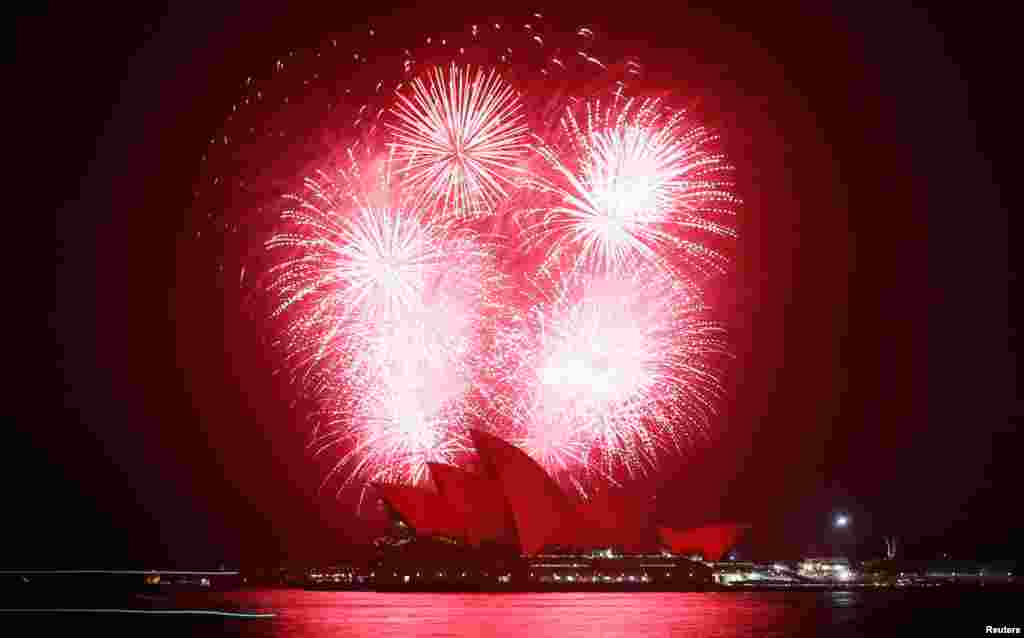 Fireworks explode over the Sydney Opera House, November 30, 2012, as it is bathed in red light to mark World AIDS Day.