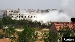 Smoke rises from a part of the Mleha town in the suburb of Damascus during the clashes between rebel fighters and forces loyal to Syria's President Bashar al-Assad, April 12, 2014.