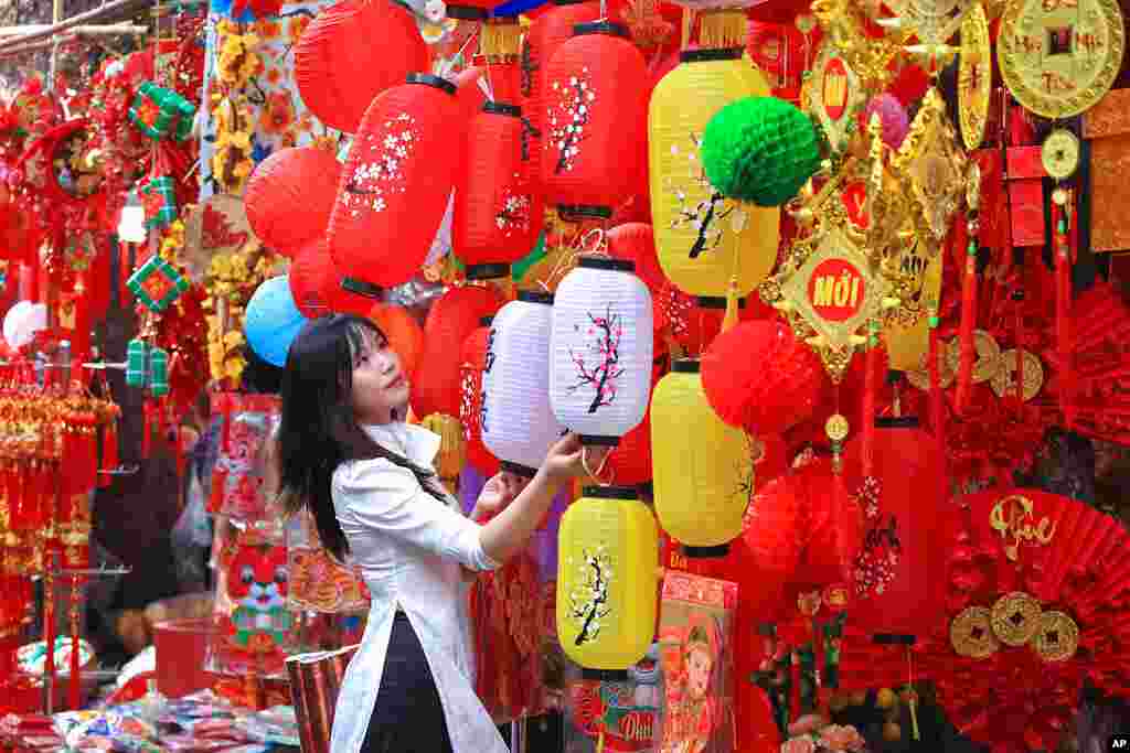 A woman looks at lanterns at the traditional Lunar New Year "Tet" market in the old quarter of Hanoi, Vietnam.
