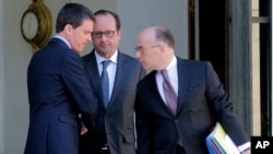 El primer ministro Manuel Vall (izquierda) y el ministro del Interior, Bernard Cazeneuve (derecha) salen del palacio de los Elíseos en París.