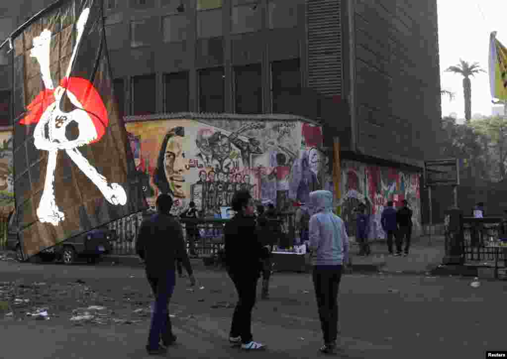 Youths walk next to a pirate flag on display by a street vendor in Tahrir Square, Cairo, Egypt, November 29, 2012.